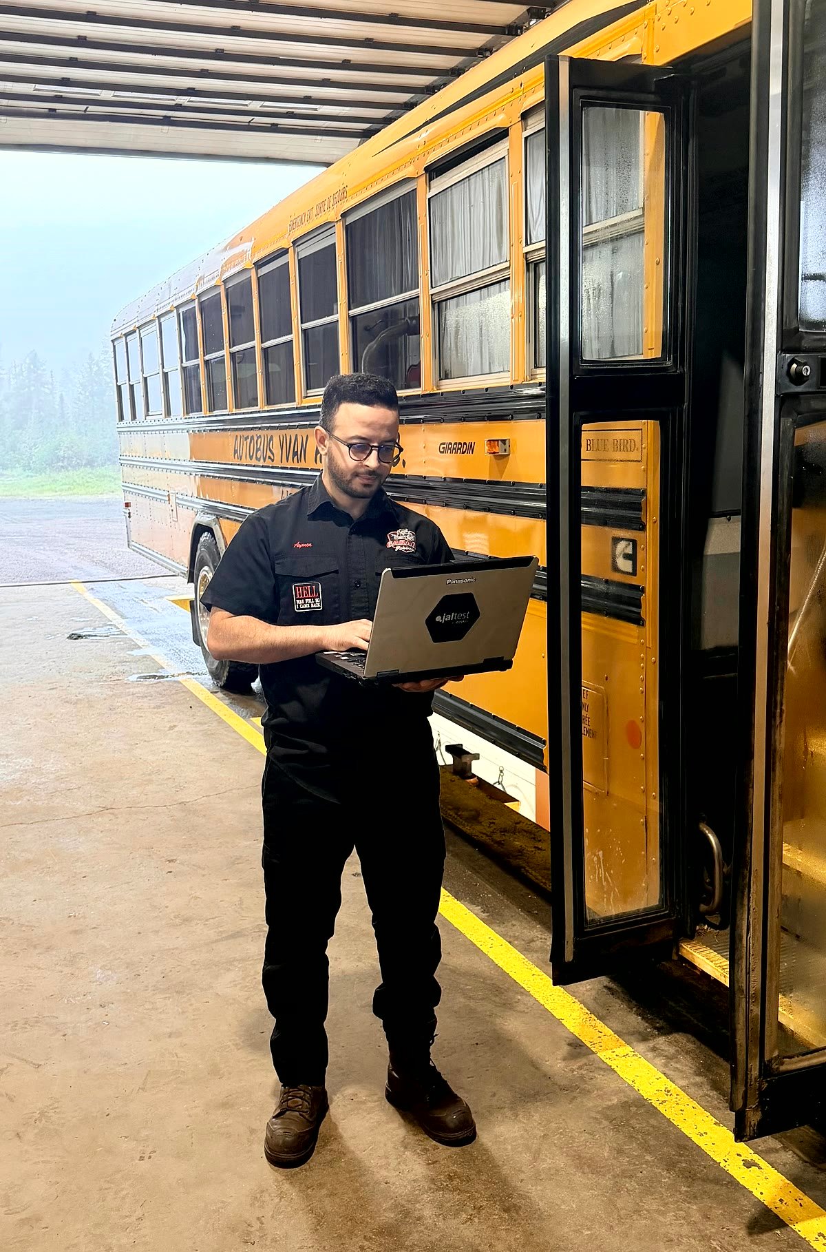 Technician performing an electronic diagnostic on a bus with a Jaltest tool