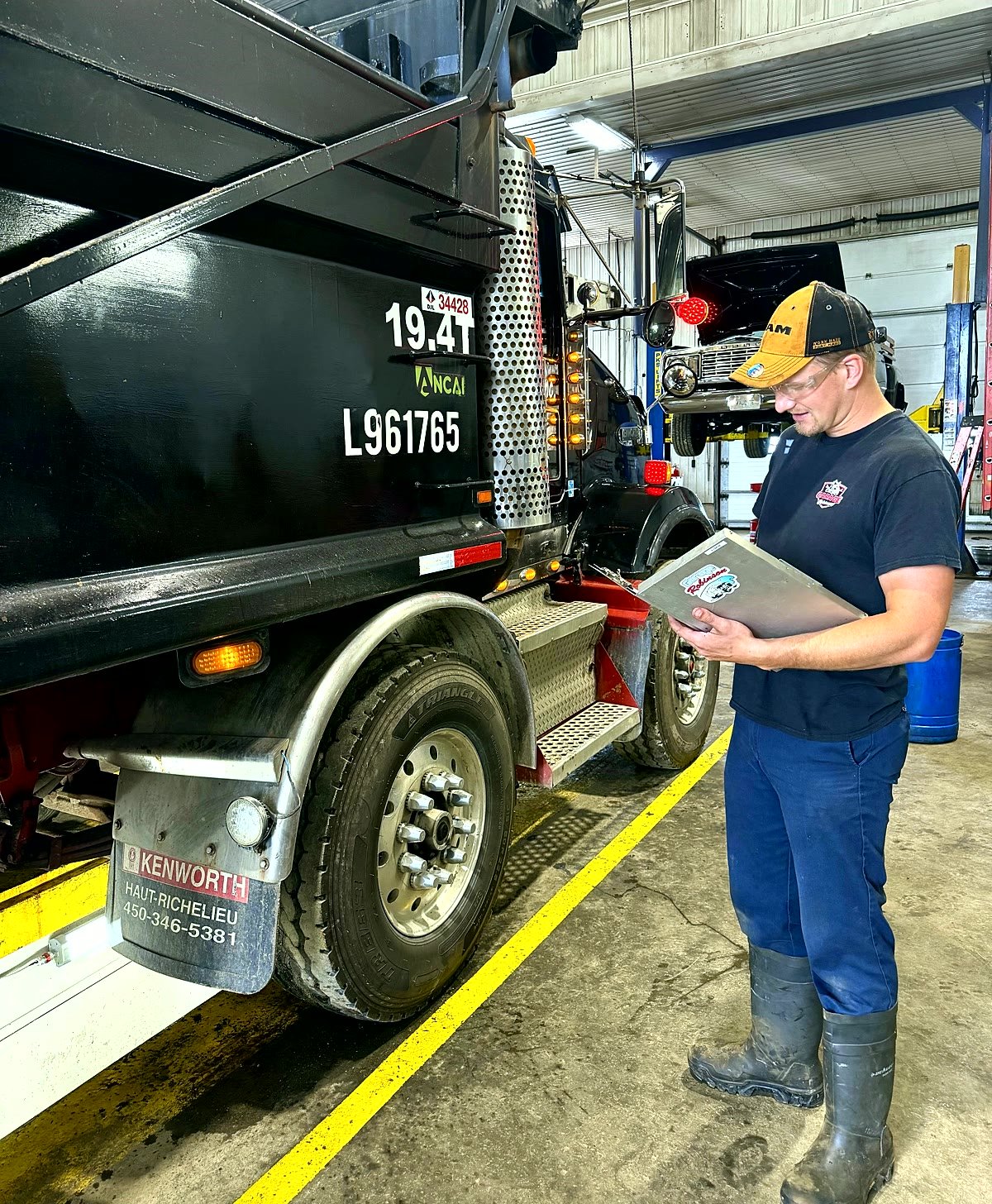 Technician performing a complete mechanical inspection on a Kenworth truck